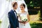 Newlyweds look funny standing in the front of white altar in the