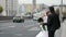 newlyweds in megapolis, loving couple in wedding clothes is walking on street