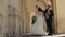 Newlyweds portrait, caucasian groom bride dancing, embracing, hugs on city street, wedding couple