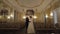 Newlyweds portrait, caucasian groom bride walking, embracing, hugs in large room, wedding couple