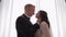 Newlyweds portrait, caucasian groom bride walking, embracing, hugs in large room, wedding couple