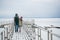 Newlyweds spend their honeymoon in the village, on a snow-covered lake, walking along the pier