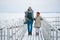 Newlyweds spend their honeymoon in the village, on a snow-covered lake, walking along the pier