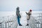 Newlyweds spend their honeymoon in the village, on a snow-covered lake, walking along the pier