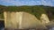 Newlyweds stand on the high seashore. The camera moves away from them, revealing the perspective and beauty of the