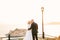 Newlyweds stand kissing on an observation deck overlooking the island of Sveti Stefan, near Budva, Montenegro