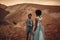 Newlyweds walk in canyon at sunset.