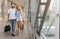 Newlyweds walking in airport terminal walkway, copy space