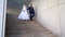 Newlyweds are walking up the stairs