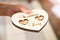 Newlyweds wedding rings on a wooden heart-shaped stand in the church