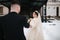 Newlyweds in witer park are walking around. Handsome groom and beautiful bride surrounded by snow. Winter wedding