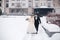 Newlyweds in witer park are walking around. Handsome groom and beautiful bride surrounded by snow. Winter wedding