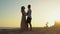 Newlyweds, a young couple at a romantic meeting on the seashore at sunset dancing in slow motion.