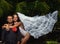 Newmaried couple stay together against tropical background