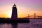 Newport Harbor Lighthouse with bridge and colorful sky