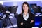 News writing and reporting.Woman journalist in television studio standing with her arms crossed