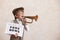 Newsboy shouting against grunge wall background. Boy selling fake news