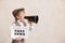 Newsboy shouting against grunge wall background. Boy selling fake news