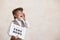 Newsboy shouting against grunge wall background. Boy selling fake news