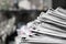 Newspapers folded and stacked on the table dark background. Image shallow depth of field