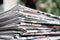 Newspapers folded and stacked on the table with gardenor green background. Closeup newspaper and selective focus image. Time to re