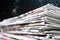 Newspapers folded and stacked on the table modern dark background. Closeup newspaper.