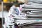 Newspapers folded and stacked on the table with outdoor garden or bright color background. Closeup newspaper and selective focus i