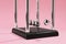 Newton`s cradle on pink background, closeup. Physics law of energy conservation