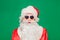 Newyear atmosphere presents, wear red santa costume sunglass headwear. isolated green color background