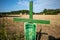 Next to  grain field there is a green cross as a symbol of protest of the farmers