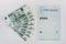 Next to the health insurance policy is fan of thousand-pack of banknotes, white background