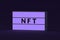 NFT inscription on glowing lightbox. Non-fungible token. Blockchain technology concept