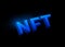 NFT non fungible tokens concept vector background. Big 3d blue shiny letters sign isolated on dark black backdrop