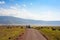 Ngorongoro National Park, Tanzania. Road through a wildlife park with herd of grazing Wildebeest and Zebra
