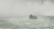 Niagara falls tourist cruise boat turbulent river water in mist 4K
