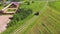 Nice aerial view of a tractor carrying a cart of grass in the field.