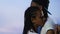 Nice Afro-American teen couple tenderly hugging against sky background, support