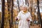 nice american gray haired lady in autumn park, holding nordic poles in hands, enjoying