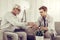 Nice-appealing male giving an aged relative a glass of water