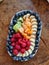 nice arranged fruits on a plate, blueberries, raspberries, kiwis