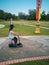 A nice Asian young girl is riding a scooter. Active leisure in the park.