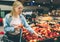 Nice and attractive youn woman is taking some apples at the store. She is choosing the best one.