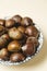 A nice bowl of chestnuts on beige background