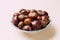 A nice bowl of chestnuts on beige background