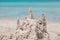 Nice built sand castle using a child\'s fantasy on the background of turquoise tranquil inviting ocean