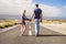 Nice caucasian couple in relationship taking hands and walk together on a long way road straight to the future. life forever in