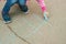 Nice Caucasian Little Girl Draw Chalk on Asphalt Lines Blue Chalk Educative Parenting Activity for Children. copy space.