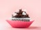 Nice chocolate cupcake with hearts, pink background