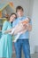 Nice close-knit family of mom, dad and daughter posing in their white room