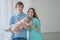 Nice close-knit family of mom, dad and daughter posing in their white room